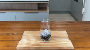 Glass holding cooked brown tapioca pearls with one quarter glass of ice cubes on top of the pearls