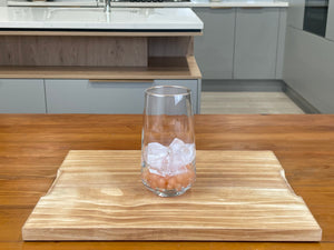 Serving glass holding cooked Red Grapefruit tapioca fruit pearls, with one quarter glass of ice cubes on top of the pearls
