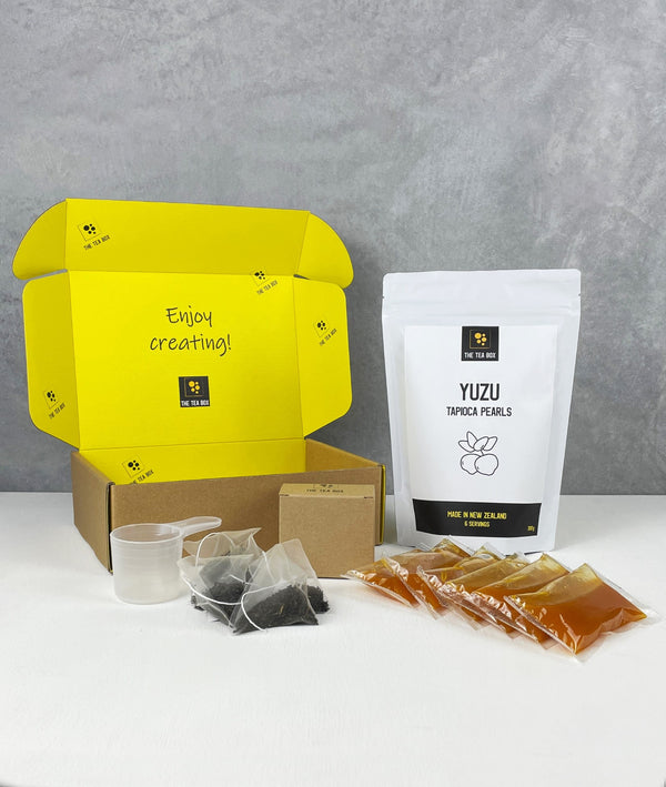 Contents of 6 pack Mango Bubble Tea Kit. Yuzu pearls in pouch, sachets of fruit mix, tea bags, scoop and cardboard gift box