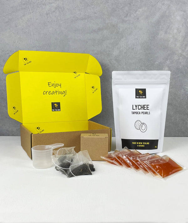 Contents of 6 pack Peach Bubble Tea Kit. Lychee pearls in pouch, sachets of fruit mix, tea bags, scoop and cardboard gift box