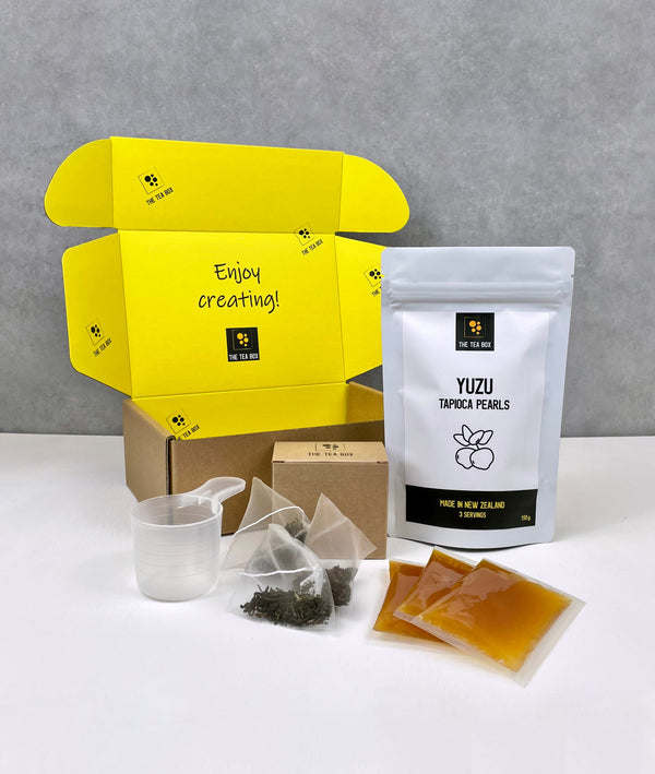 Contents of 3 pack Lychee and Passionfruit Bubble Tea Kit. Yuzu pearls in pouch, sachets of fruit mix, tea bags, scoop and cardboard gift box