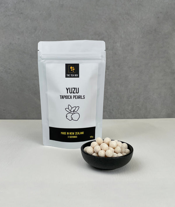 Resealable pouch holding 3 servings of Yuzu tapioca fruit pearls. Displayed with uncooked Yuzu pearls in a small ceramic dish