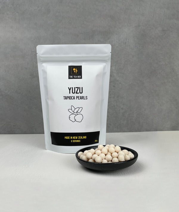 Resealable pouch holding 6 servings of Yuzu tapioca fruit pearls. Displayed with uncooked Yuzu pearls in a small ceramic dish