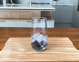 Glass holding cooked dark purple Blueberry tapioca fruit pearls with one quarter glass of ice sitting on top of the pearls