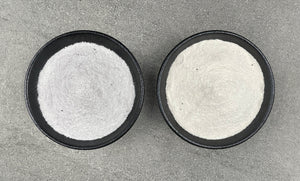 Off-white coloured Dairy and Non-Dairy creamers in two round black ceramic dishes