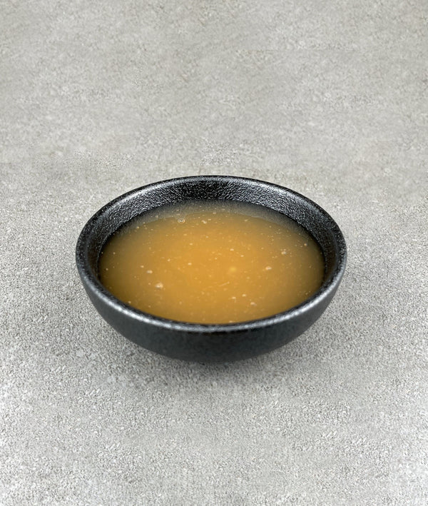 Small black ceramic dish filled with light yellow-beige Lychee fruit mix