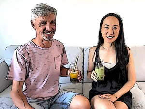 Sitting on a couch, smiling. Ron holds a Passionfruit bubble tea with Blueberry pearls. Marie has a Matcha Latte bubble tea with blueberry pearls