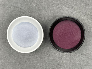 Two round ceramic dishes, holding light purple taro powder and another holding bright purple taro mixture when the taro powder has been dissolved in hot water