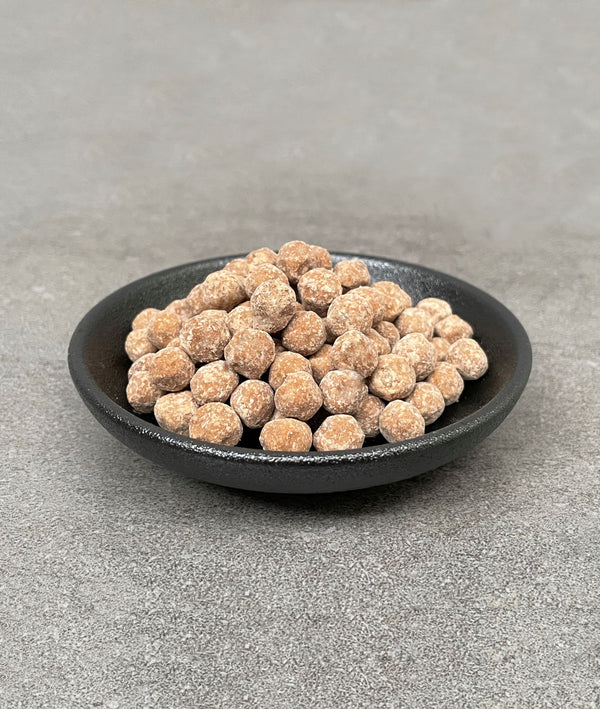 Uncooked Brown tapioca pearls in a small black ceramic dish