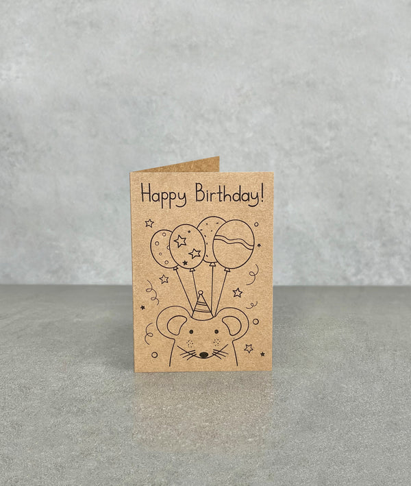 Happy Birthday card made of brown kraft card. Shows a cartoon mouse smiling wearing party hat with 4 balloons. Card measures 70 x 100 mm when folded