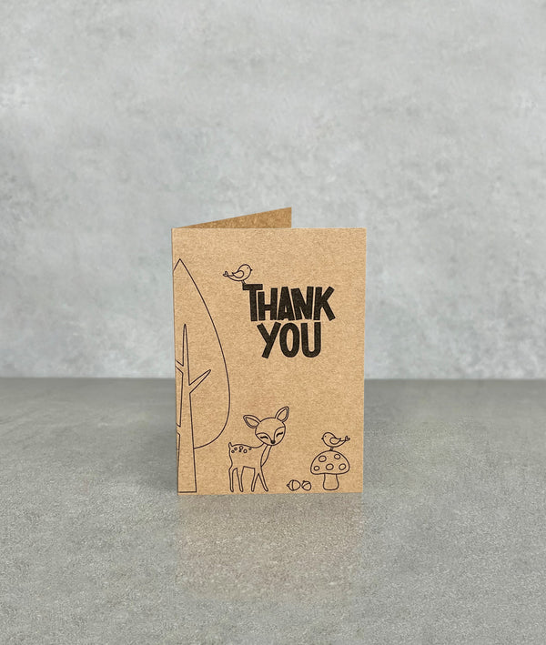 Thank You card made of brown kraft card. Shows cartoon woodland scene including a deer, toadstool, bear, birds. Card measures 70 x 100 mm when folded