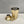 Load image into Gallery viewer, Unassembled brushed gold 3-piece shaker. Showing the cup, strainer and cap
