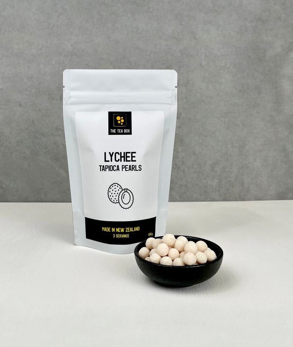 Resealable pouch holding 3 servings of Lychee tapioca fruit pearls. Displayed with uncooked Lychee pearls in a small ceramic dish