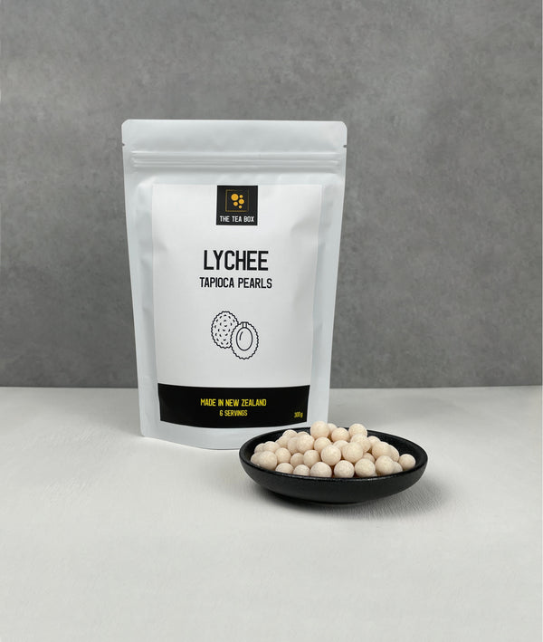 Resealable pouch holding 6 servings of Lychee tapioca fruit pearls. Displayed with uncooked Lychee pearls in a small ceramic dish