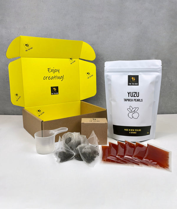 Contents of 6 pack Red Grapefruit Bubble Tea Kit. Yuzu pearls in pouch, sachets of fruit mix, tea bags, scoop and cardboard gift box 