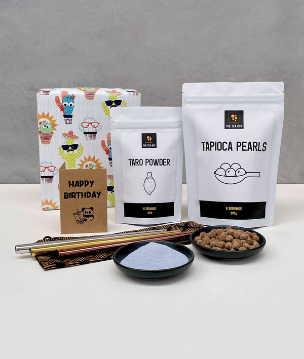 6 pack Taro Bubble Tea gift pack. Taro powder and brown tapioca pearls in pouches and displayed in small black ceramic dishes, 3 stainless steel bubble tea straws (silver, gold and rose gold) with drawstring bag, greeting card and wrapped gift box