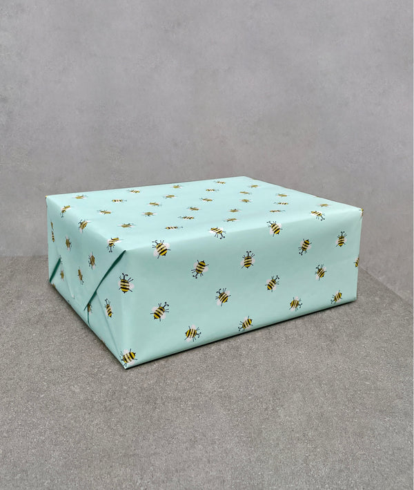 Bees gift wrapping paper. Light aqua blue background covered with hand-drawn bumble bees