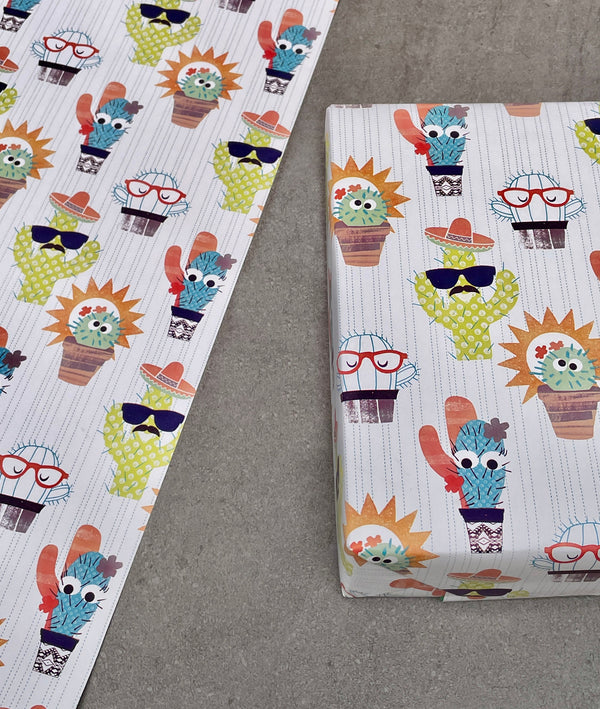 Cactus gift wrapping paper. Multicoloured cartoon cacti wearing hats and sunglasses on a white background