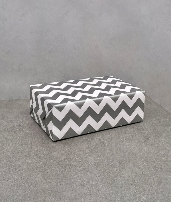 Chevron gift wrapping paper. Grey and white zig-zag pattern on gloss paper