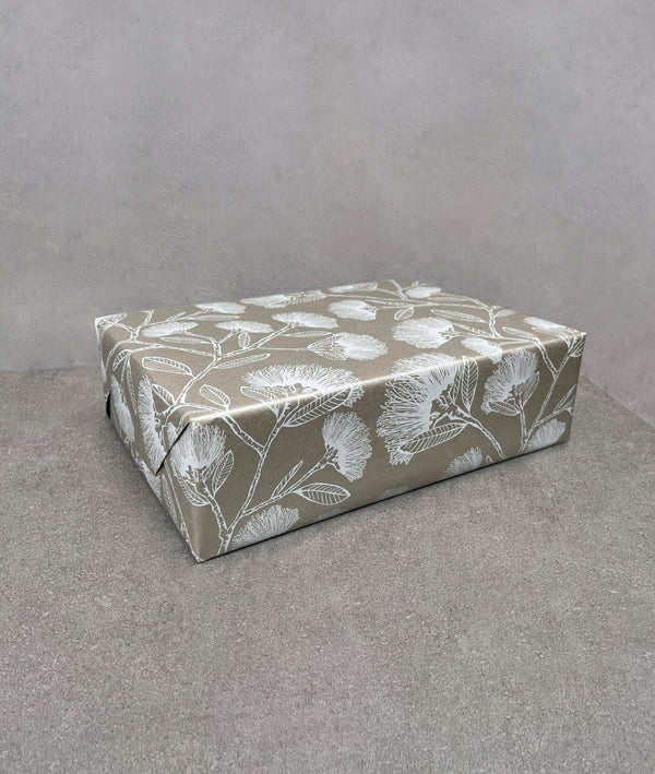 Pohutukawa wrapping paper. Silvery brown background covered in white pohutukawas